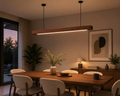 UNIKAA modern linear wooden pendant light for office space styled in a modern living and dining area with warm ambient evening lighting.